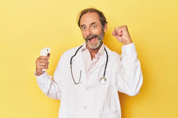 Doctor Holding Infrared Thermometer Studio Raising Fist Victory Winner Concept — Stock Photo, Image