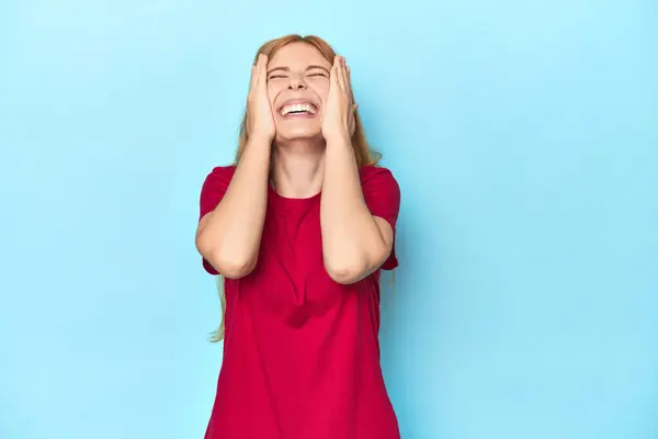 Roodharige Jonge Vrouw Blauwe Achtergrond Lacht Vreugdevol Het Houden Van — Stockfoto