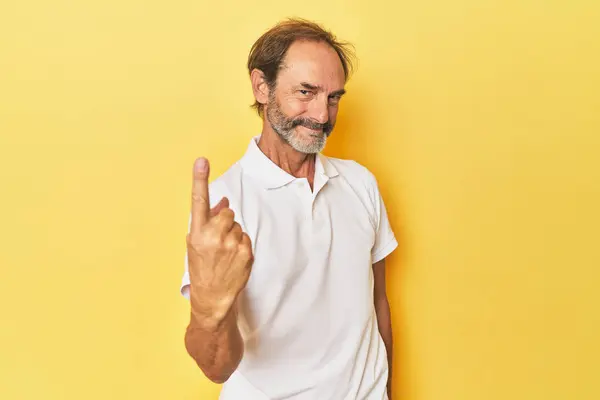 イエロースタジオのコーカサス中年の男性が 招待が近づくかのように指で指を指差します — ストック写真