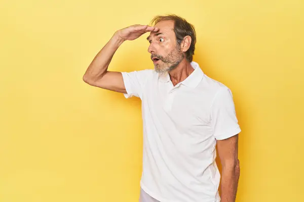 Caucásico Hombre Mediana Edad Estudio Amarillo Mirando Lejos Manteniendo Mano — Foto de Stock