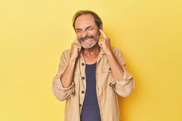 Omul Vârstă Mijlocie Caucazian Studioul Galben Care Acoperă Urechile Mâinile — Fotografie, imagine de stoc