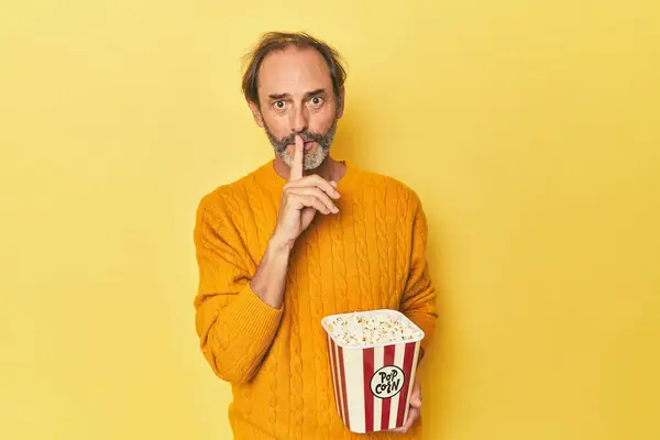 Man Enjoying Popcorn Yellow Studio Keeping Secret Asking Silence — Stock Photo, Image