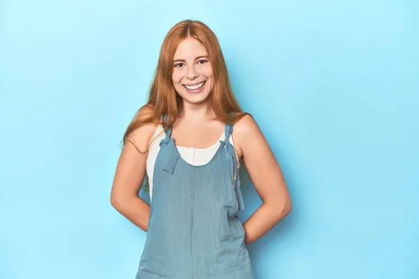 青い背景の赤毛の若い女性幸せ 笑顔と陽気 — ストック写真