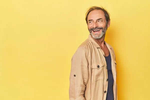 Caucasian Middle Aged Man Yellow Studio Looks Aside Smiling Cheerful — Stock Photo, Image