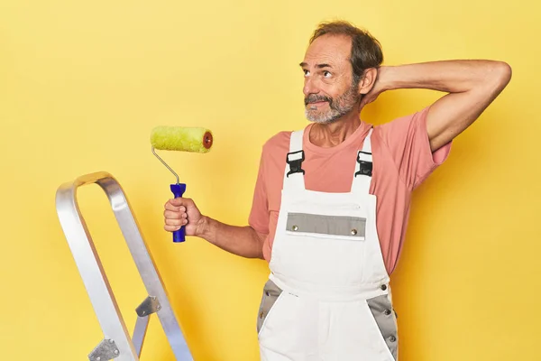 Man Painting Yellow Backdrop Studio Touching Back Head Thinking Making — Stock Photo, Image