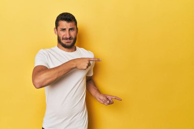 Sarı arka plandaki genç İspanyol adam işaret parmaklarıyla bir fotokopi alanını işaret ederek şok oldu..