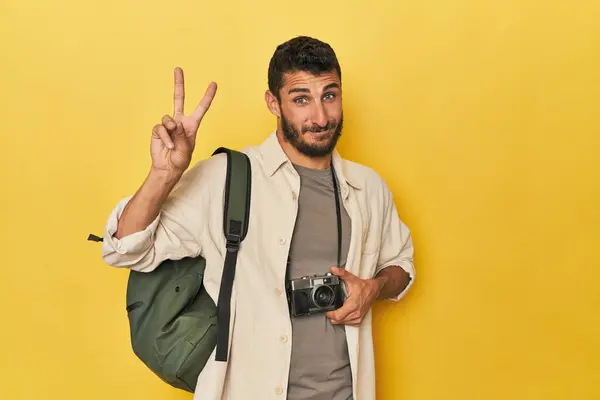 年轻的西班牙裔旅行摄影师摆姿势 用手指展示第二名 — 图库照片