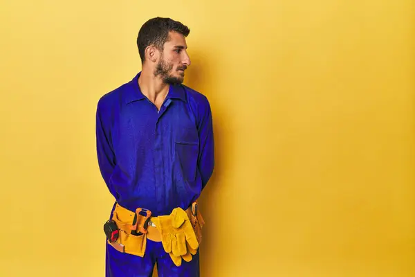 身穿蓝色工作服 手持工具的西班牙裔年轻人 — 图库照片