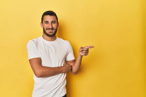 Young Hispanic Man Yellow Background Smiling Cheerfully Pointing Forefinger Away — Stock Photo, Image