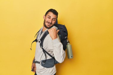 Genç İspanyol adam yürüyüş için hazır başparmak uzakta, gülüyor ve kaygısız.