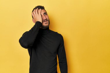 Sarı arka plandaki genç İspanyol adam gülüyor mutlu, kaygısız, doğal duygu.