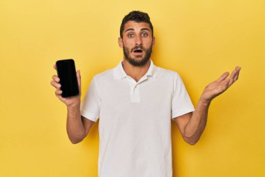 Genç İspanyol adam telefon ekranında güzel bir sürpriz yakaladı. Heyecanlı ve el kaldırıyor..