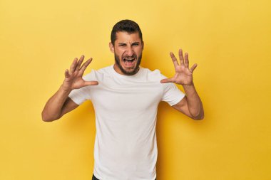 Sarı arka plandaki genç İspanyol öfkeyle bağırıyor..