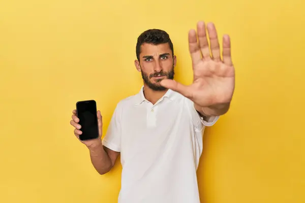 Young Hispanic Man Shows Phone Screen Standing Outstretched Hand Showing — Stock Photo, Image