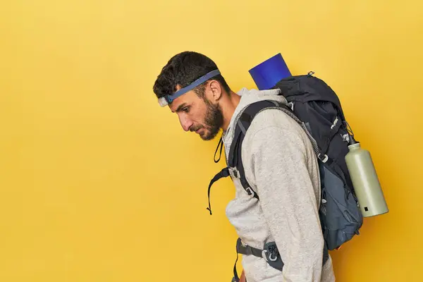 Hispanic man with backpack and headlamp