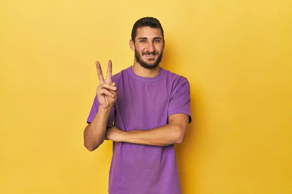 Sarı Arka Plandaki Genç Spanyol Adam Iki Numarayı Parmaklarıyla Gösteriyor Telifsiz Stok Imajlar