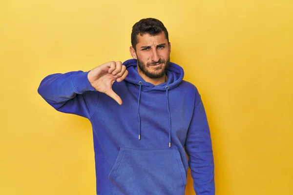Young Hispanic Man Yellow Background Showing Thumb Disappointment Concept Stock Picture