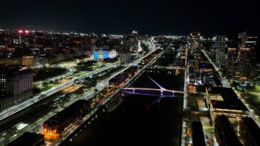 Buenos Aires, Arjantin, 14 Eylül 2024: Günbatımında Puerto Madero kentsel manzarası, arka planda Buenos Aires şehri. Hava gece görüntüsü.