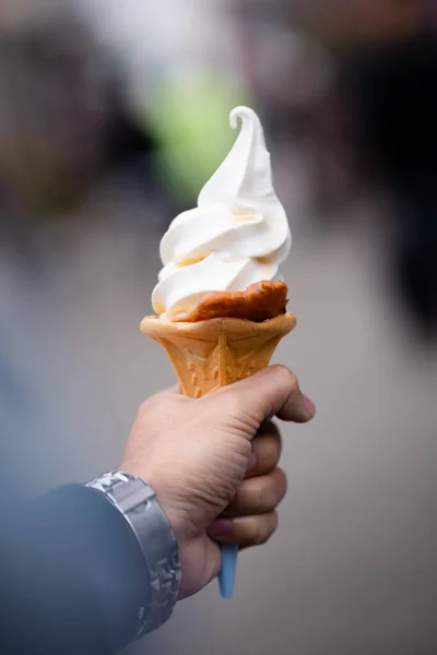 stock image hand holding vanilla ice cream cone 