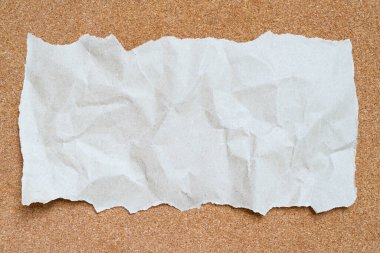 Beyaz desenli boş kağıt levha ve kahverengi mantar kaplama yüzeyinde yeşil maske bandı. Metin ya da sanat tasarımı eklemek için boşluk kopyala.