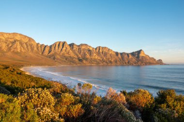 Kogel Körfezi Sahili ve Kogelberg Dağları 'nın güzel akşam manzaraları çok güzel bir zemin oluşturuyor. Overberg. Batı Burnu. Güney Afrika