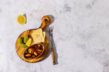 Tinned mussels board, Spanish conservas with olives. Mediterranean appetizer platter with crackers. Top view, copy space. 