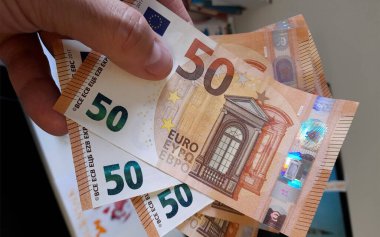 Banknotes of 50 euros in the hands of a wealthy man clipart