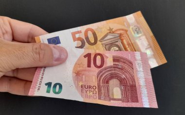 50 euro banknote and 10 in the hands of a man - wealth clipart