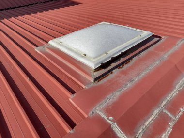 Su geçirmez kılıfların durumu nedeniyle bariz sızma sorunları olan terk edilmiş bir sanayi deposunun eski yalıtılmış metal çatısı.