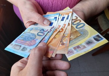Bir kişinin elinde 20, 50 ve 200 avroluk banknotlar - zenginlik