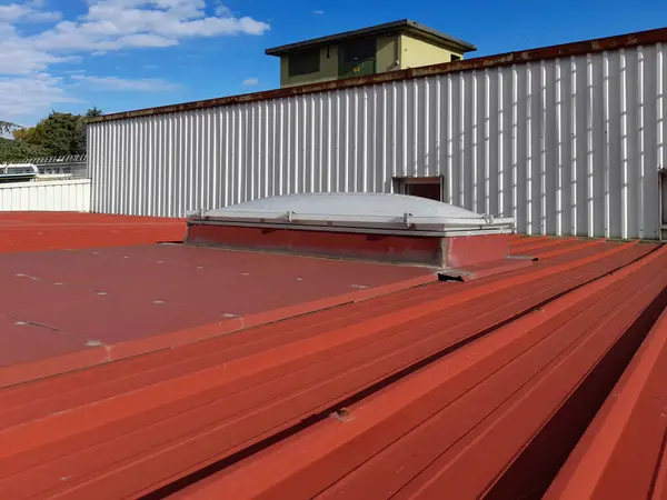 Terk edilmiş bir sanayi barakasının çatı penceresi ve su geçirmez kılıfların durumu nedeniyle bariz sızma sorunları var.