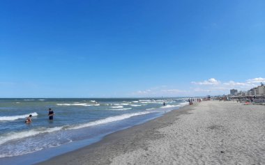 Sıcak yaz mevsiminde şemsiyeli ve şezlonglu sahil beldesi