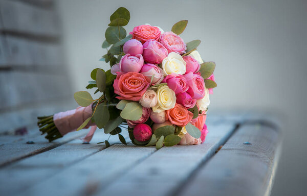 Bouquet of white and pink rose flowers on a gray wooden surface. The concept of a holiday, wedding.