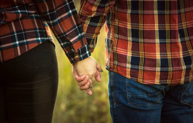 Parktaki aşıklar nazikçe el ele tutuşuyorlar, geçmişi bulanık..