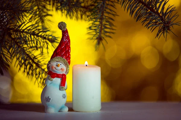 Lustiges Schneemannspielzeug Und Brennende Kerze Auf Funkelndem Und Fabelhaftem Bokeh — Stockfoto