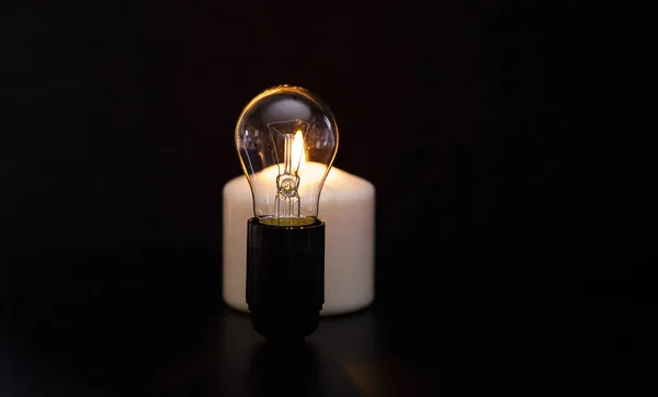在黑暗的家中 在一个关着的灯泡旁燃着蜡烛 能源危机或停电 概念形象 — 图库照片