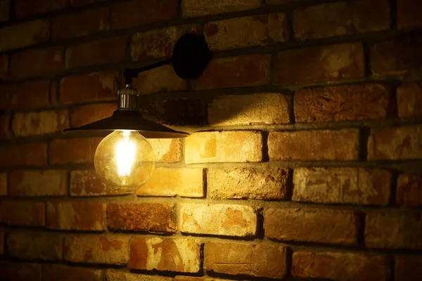 Uma Lâmpada Acesa Brilha Levemente Contra Fundo Luzes Amarelas Embaçadas — Fotografia de Stock