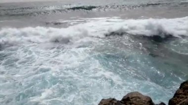 Okyanusun büyük dalgaları bulutlu bir günde kayalık bir kıyıya çarpıyor. Kanarya Adaları, Tenerife, İspanya 'da bir fırtına sırasında.