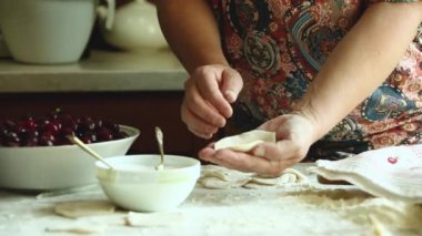 Geleneksel Ukrayna mutfağının ev yemeği. Vişneli Vareniki. Bir kadın hamuru oklavayla yuvarlar ve köfte heykeli yapar..