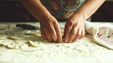 Geleneksel Ukrayna mutfağının ev yemeği. Vişneli Vareniki. Bir kadın hamuru oklavayla yuvarlar ve köfte heykeli yapar..