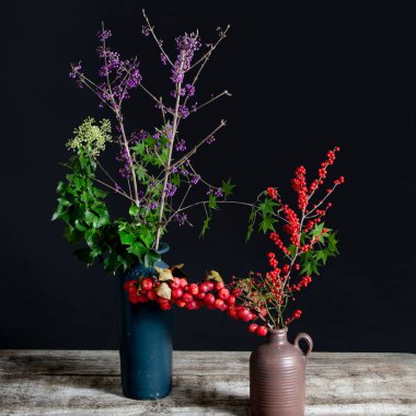 Callicarpa ve Hedera helix ve Ilex mavi ve kahverengi vazolarda. Yüksek kalite fotoğraf