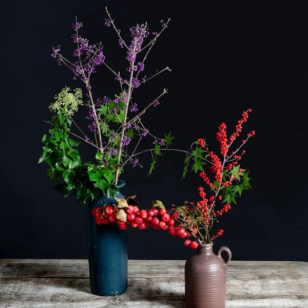 stock image Callicarpa and Hedera helix and Ilex in blue and brown vases. High quality photo