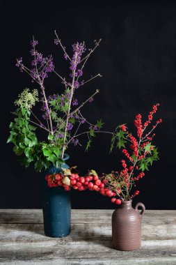Callicarpa ve Hedera helix ve Ilex mavi ve kahverengi vazolarda. Yüksek kalite fotoğraf
