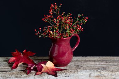 Kırmızı bir vazoda masanın üzerinde bir sürü kırmızı dut. Yüksek kalite fotoğraf