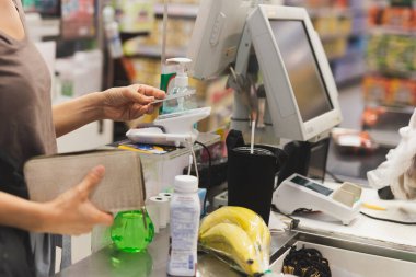 Alışveriş merkezinde NFC teknolojisi kullanan kadın müşteri ödeme yapıyor.
