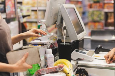 Alışveriş merkezinde NFC teknolojisi kullanan kadın müşteri ödeme yapıyor.