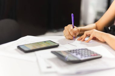 İş kadını masadaki cep telefonuyla belge imzalama anlaşması imzalıyor