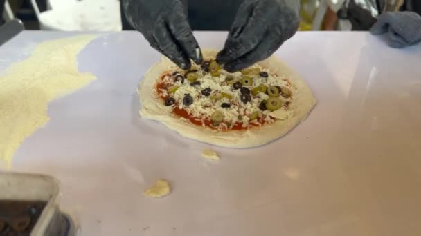 Koki Menempatkan Zaitun Hitam Dan Bahan Pada Pizza Rekaman Berkualitas — Stok Video