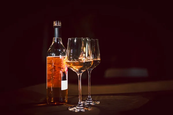 Glasses and bottle of rose wine on dinner table