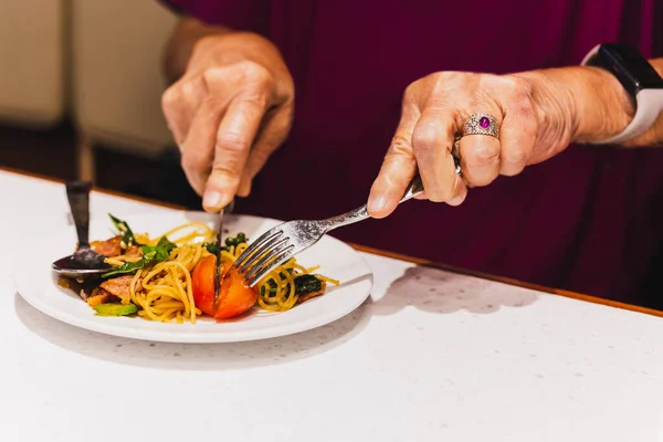 Kvinde Spiser Italiensk Pasta Med Tomat Med Kniv Gaffel - Stock-foto